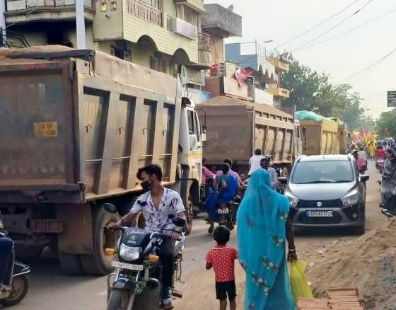 नगर के बीचोंबीच दौड़ रही रेत भरी हाईवा