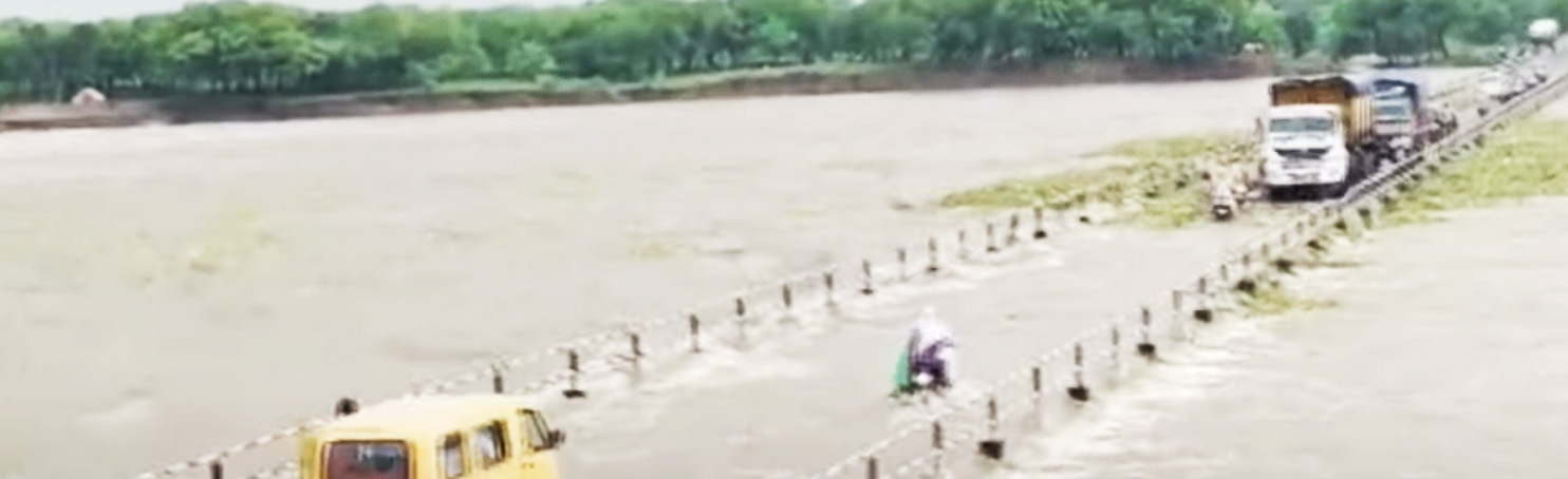 वाहन चालक उफनती नदी को कर रहे पार