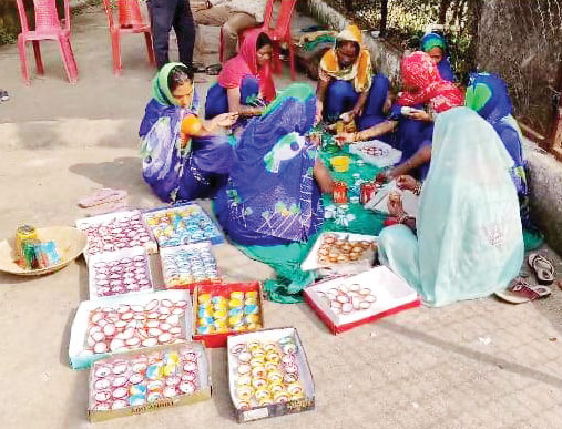 रंग-बिरंगी दीये बना रहीं समूह की महिलाएं