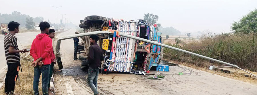 स्ट्रीट लाइट खंभे को ठोकर मारते सडक़ पर पलटा ट्रक स्ट्रीट लाइट खंभे को ठोकर मारते सडक़ पर पलटा ट्रक