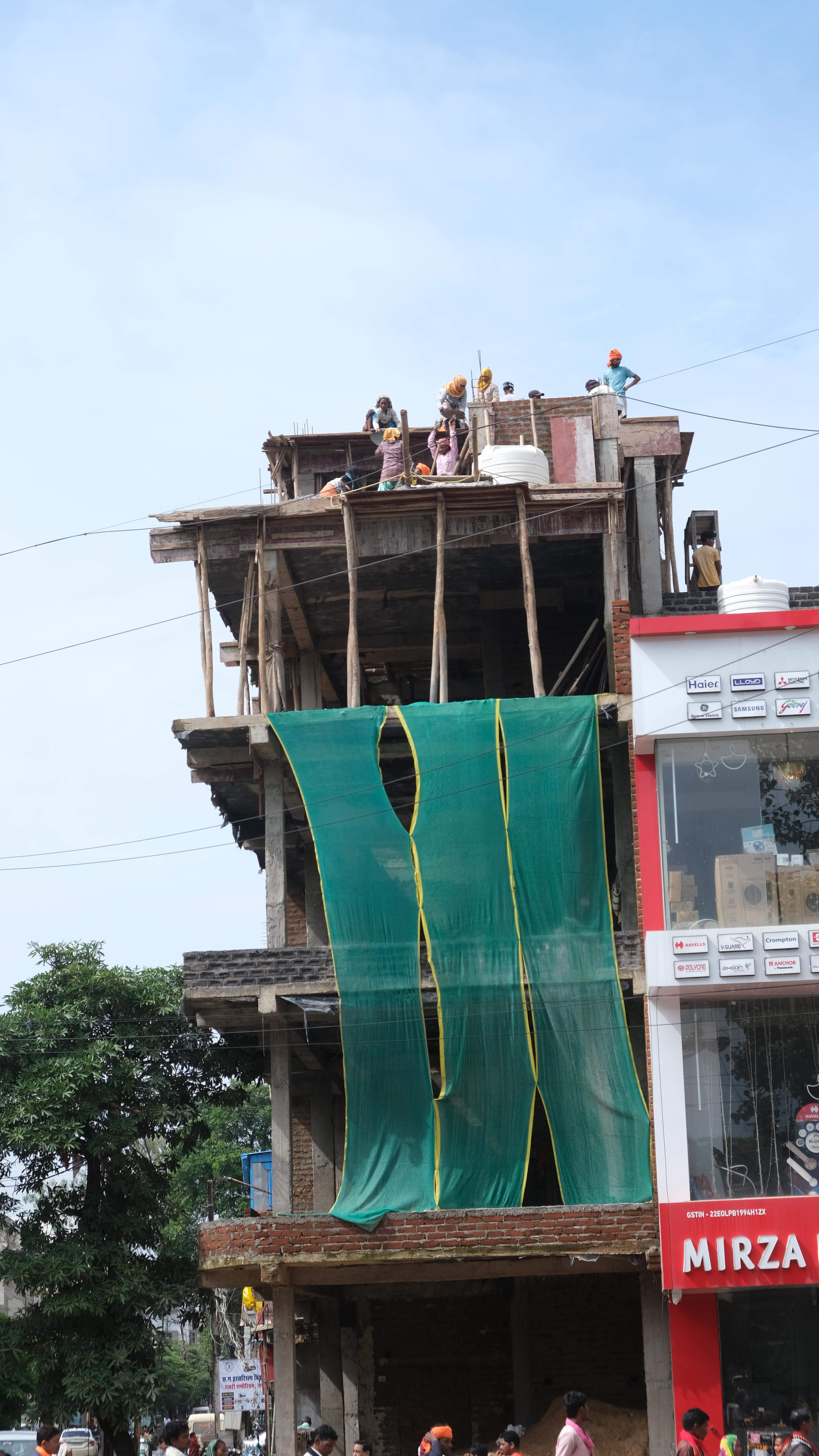 निर्माणाधीन बहुमंजिला इमारत पर  मजदूर बिना सेफ्टी बेल्ट कर रहे काम