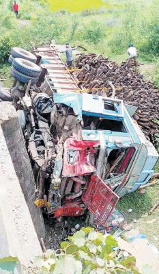 लकड़ी से भरा ट्रक अनियंत्रित होकर पुलिया से गिरा