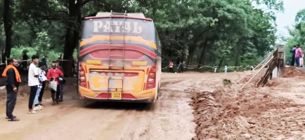 बीच जंगल कीचड़ में फंसी यात्री बस