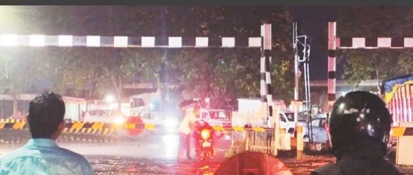 बंद रेलवे फाटक के नीचे से गुजर रहे दुपहिया चालक