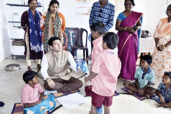 बच्चों के बीच जमीन पर बैठे कलेक्टर