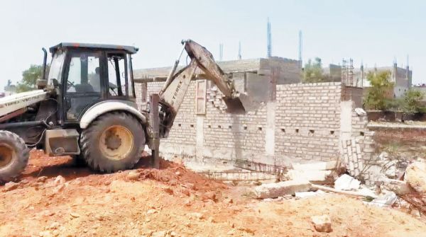 भातूपारा तालाब से अतिक्रमण हटाने जेसीबी से तोड़ी अवैध बाउंड्रीवाल