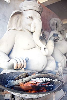 लड्डू तो जब बनेंगे, तब बनेंगे। फिलहाल तो गणेश प्रतिमा की मिट्टी जल्द सुखाने के लिए आँच दी जा रही है। तस्वीर/ ‘छत्तीसगढ़’ 